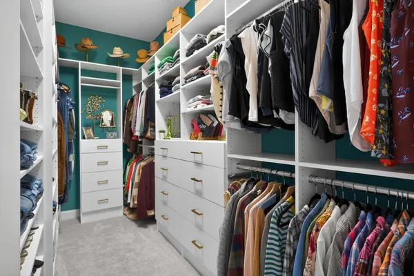 a view of walk in closet with clothes and shoes