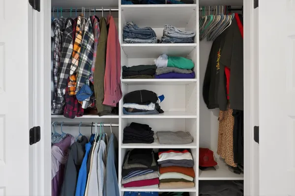 a view of walk in closet with clothes and shoes