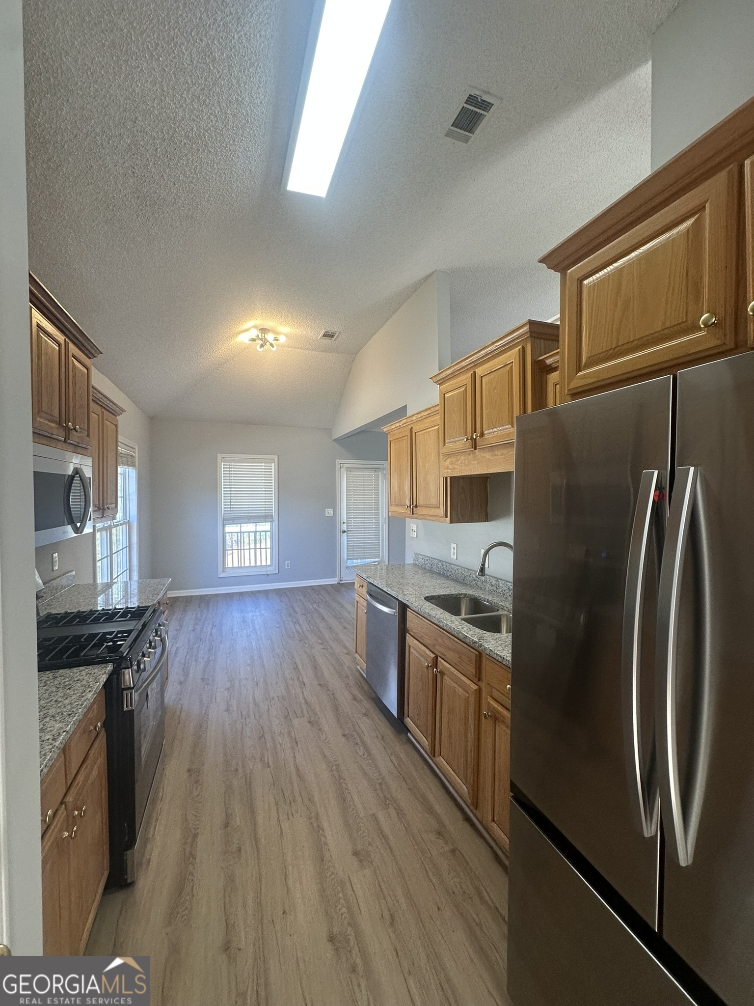 1664 Pinto Trail Jonesboro, GA 30236 - Photo 12 of 31 a kitchen with stainless steel appliances granite countertop a refrigerator a stove and a wooden floors