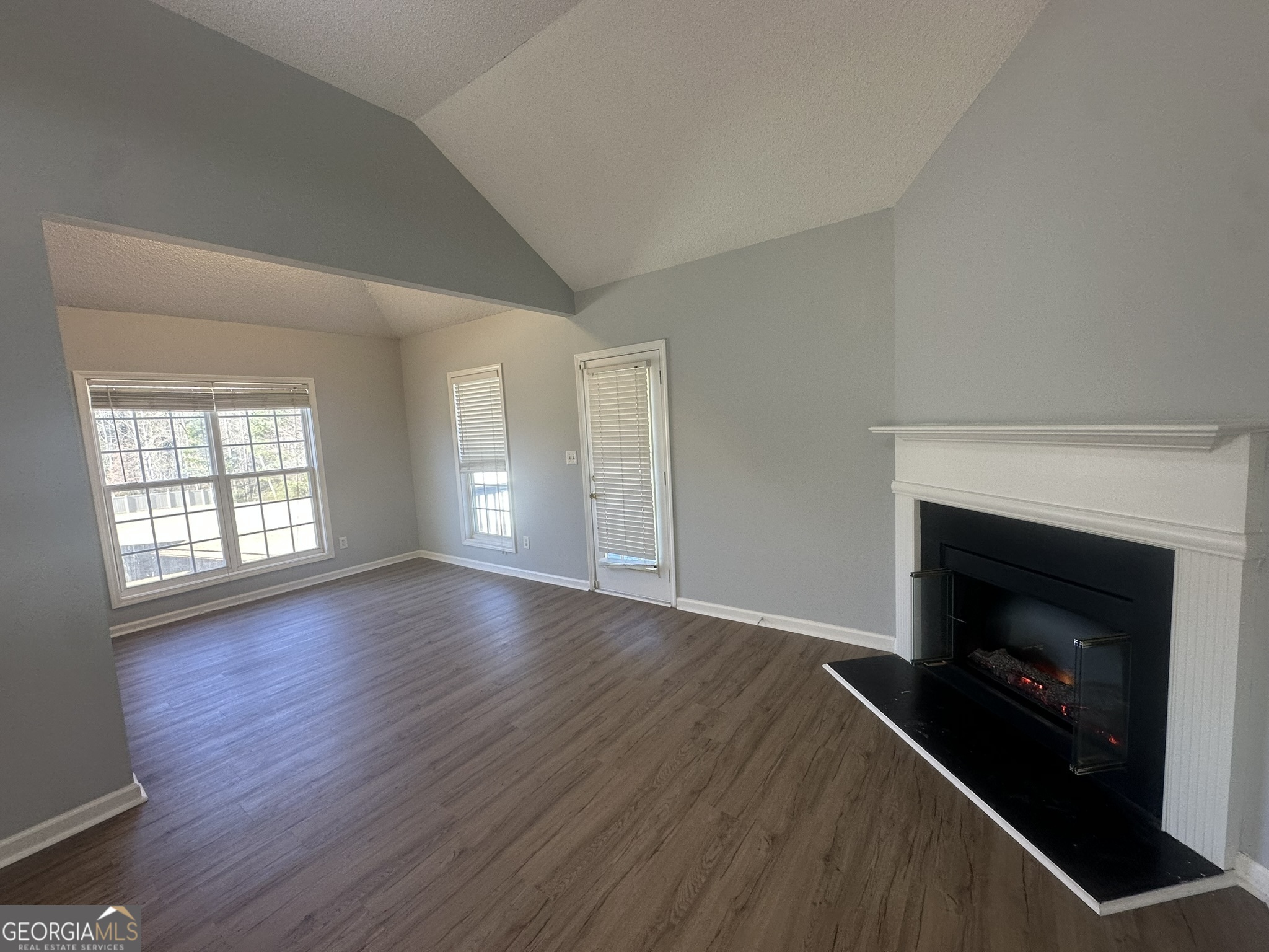 1664 Pinto Trail Jonesboro, GA 30236 - Photo 8 of 31 an empty room with wooden floor fireplace and windows