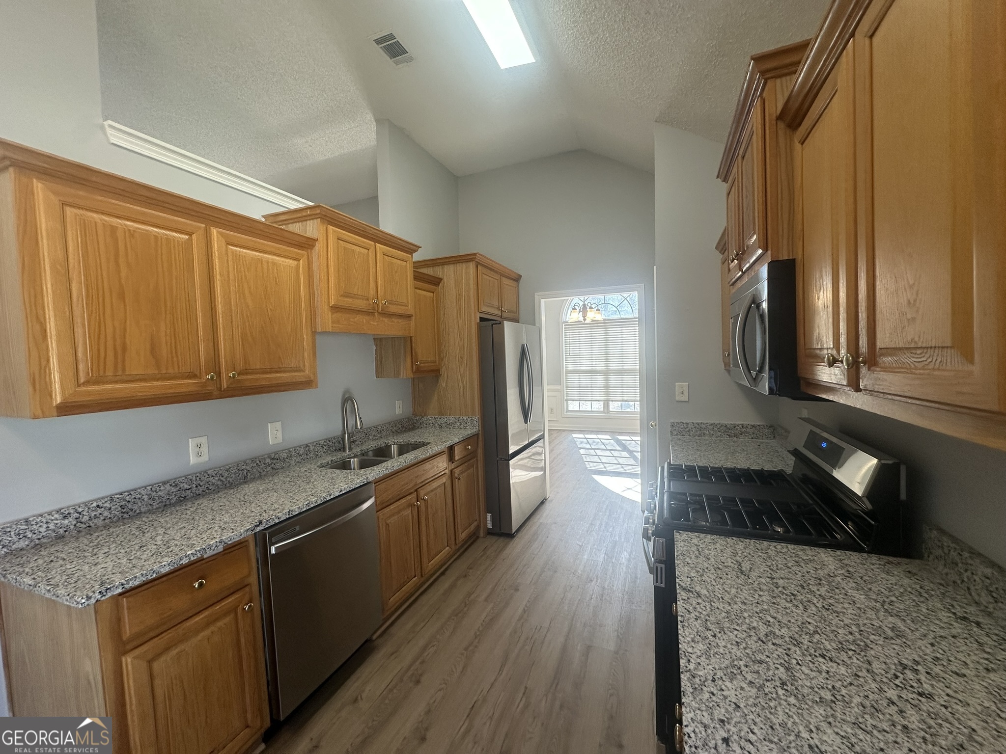1664 Pinto Trail Jonesboro, GA 30236 - Photo 10 of 31 a kitchen with granite countertop a sink a stove and wooden floor