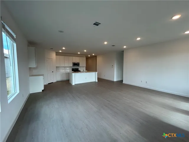 a view of a kitchen with a sink and dishwasher a refrigerator with wooden floor
