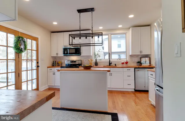 a kitchen with granite countertop a stove a sink and a refrigerator