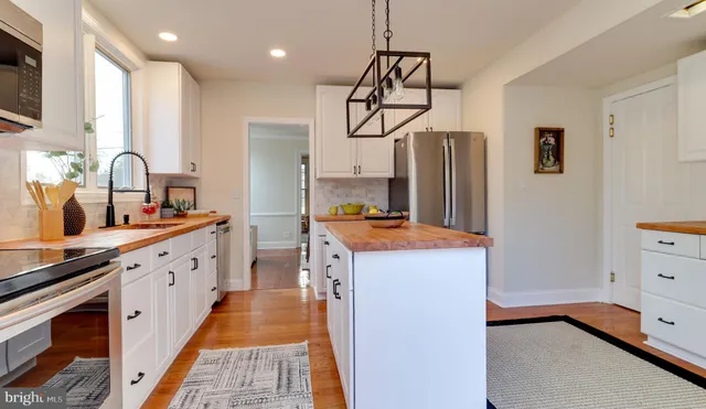 a kitchen with stainless steel appliances a sink stove and refrigerator