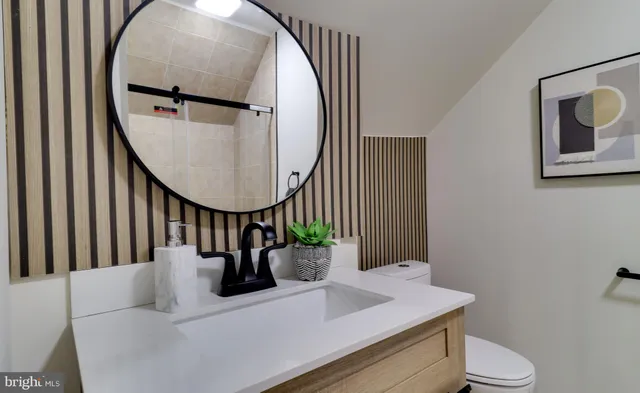 a view of hall way with furniture and a mirror