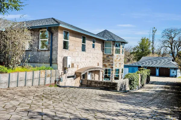 a front view of a house with a yard and a garden