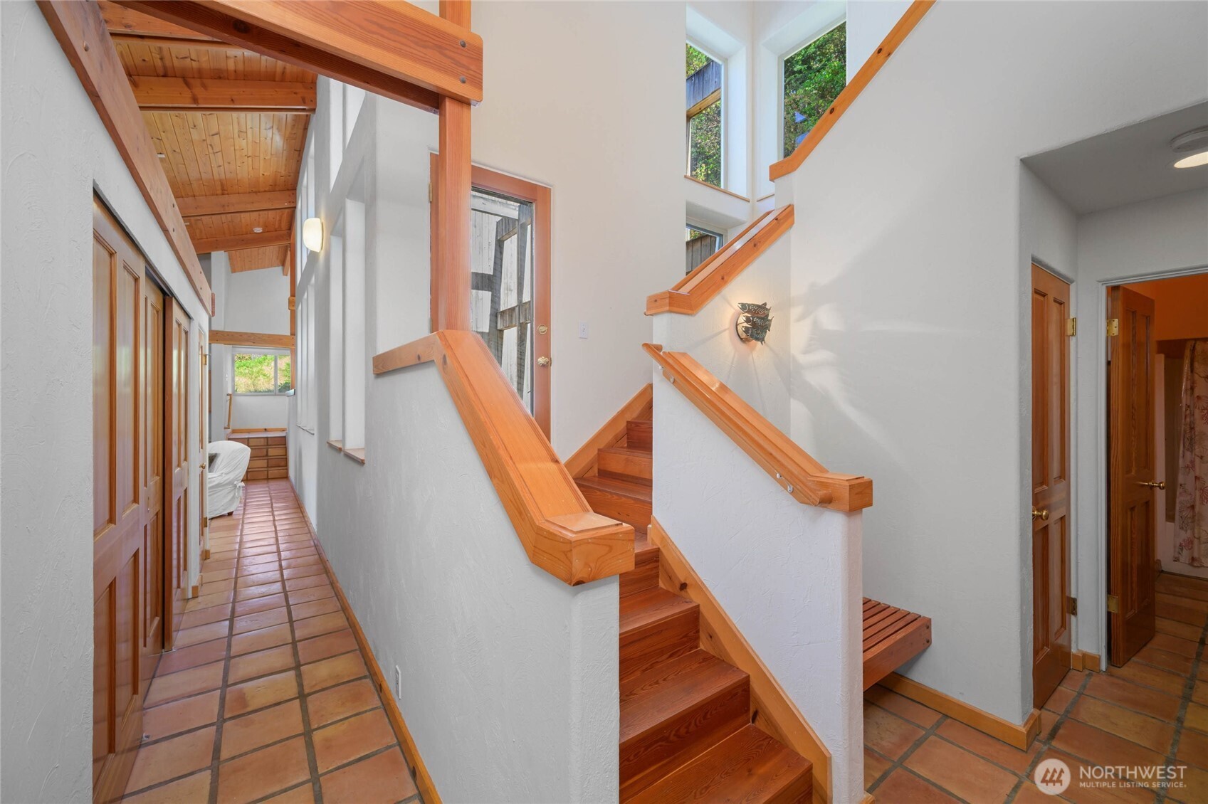 177 Harmon Ranch Hill Road Decatur Island, WA 98221 - Photo 23 of 37 a view of staircase with lots of frames on wall and a window