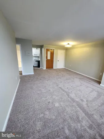 a view of an empty room with window and fireplace