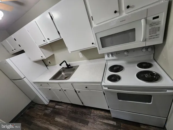 a white stove top oven sitting inside of a kitchen