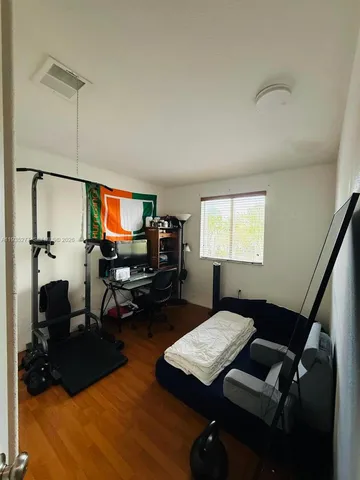 a bedroom with furniture and a wooden floor