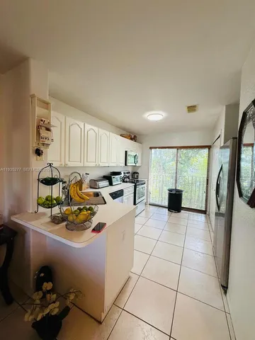 a kitchen with a sink a stove and chairs