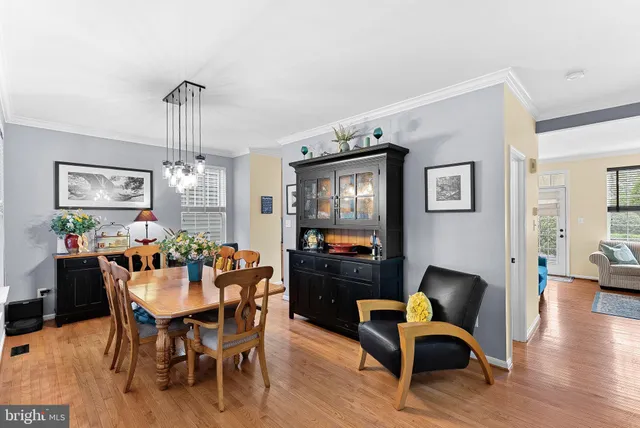 a dining room with furniture a chandelier and wooden floor