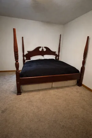 a bed sitting in a bedroom next to a window