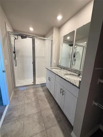 a bathroom with a granite countertop sink mirror and shower