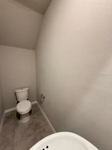 a white toilet sitting next to a white wall