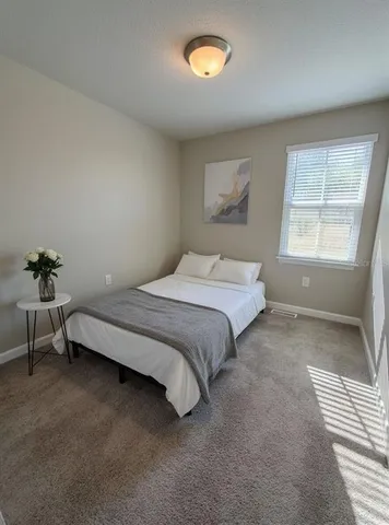 a spacious bedroom with a bed and a window