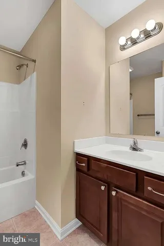 a bathroom with a tub sink and mirror