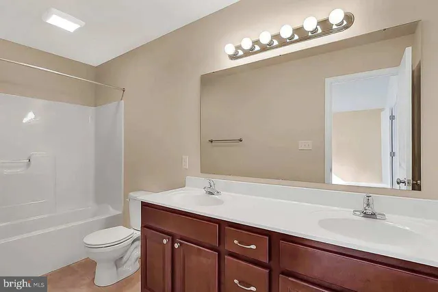 a bathroom with a sink a toilet a mirror and shower