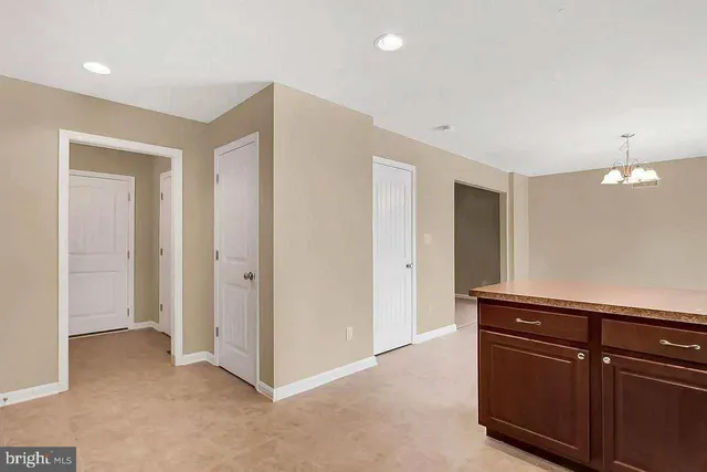a view of a hallway to room with wooden floor