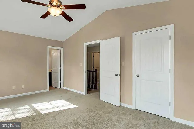 a view of a room with a ceiling fan and entryway