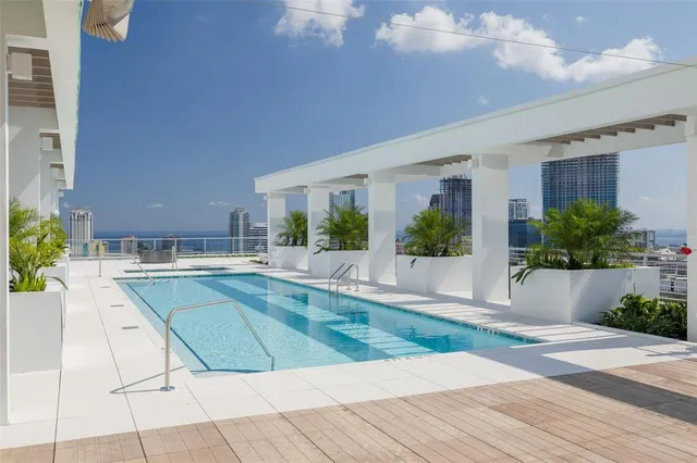 a view of a house with a swimming pool and a porch with furniture