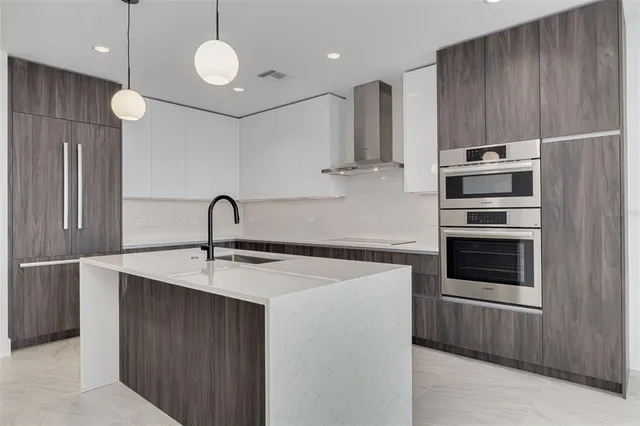 a kitchen with stainless steel appliances a stove a sink and cabinets
