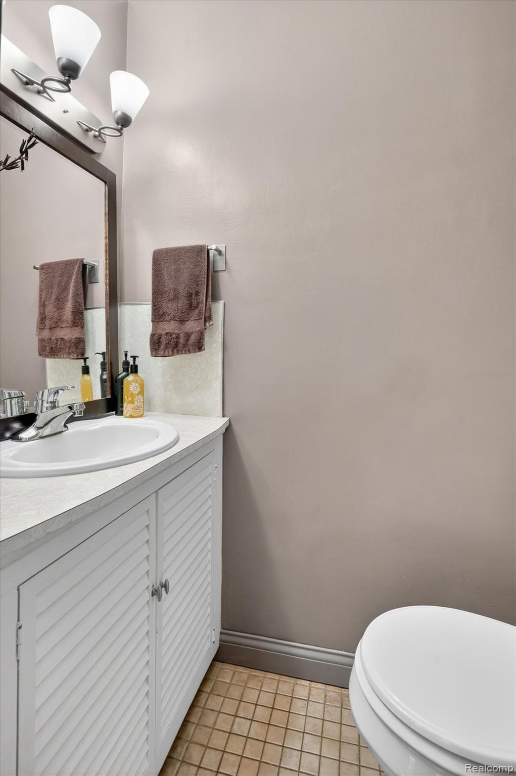 338 Kensington Road Lansing, MI 48910 - Photo 22 of 35 Half bath with vanity and light tile patterned flooring