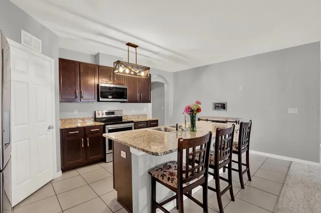 a kitchen with stainless steel appliances a stove top oven a sink dishwasher and a refrigerator