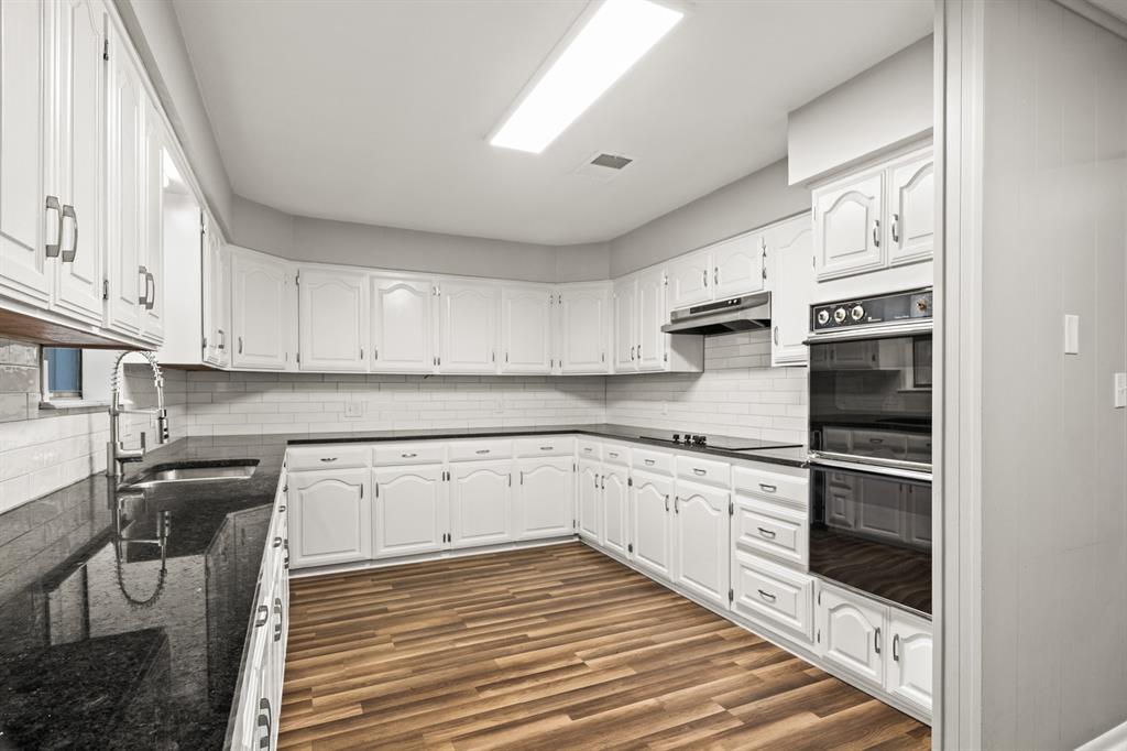 231 Quitman Street Pittsburg, TX 75686 - Photo 11 of 32 a kitchen with stainless steel appliances granite countertop a stove and cabinets
