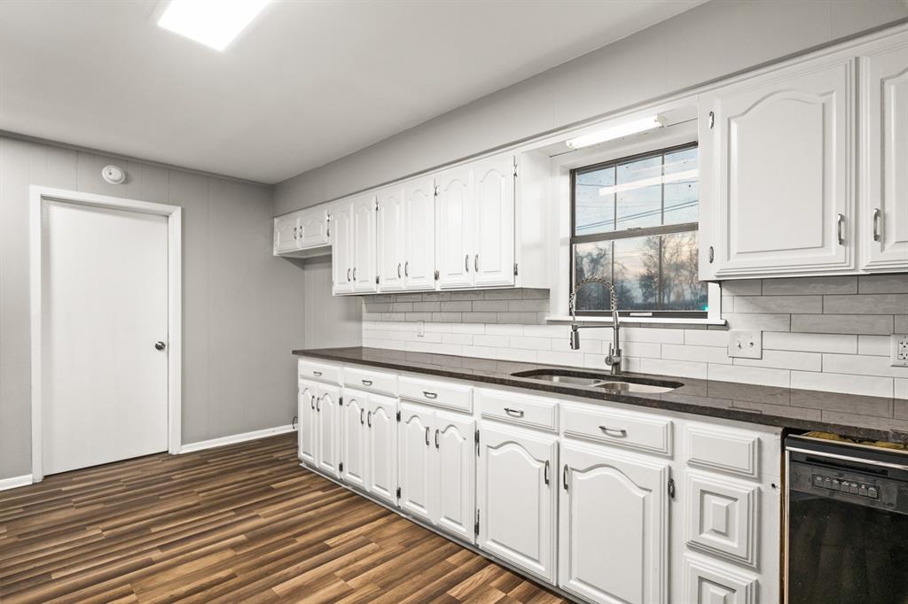 231 Quitman Street Pittsburg, TX 75686 - Photo 14 of 32 a kitchen with stainless steel appliances granite countertop a sink and a wooden floors