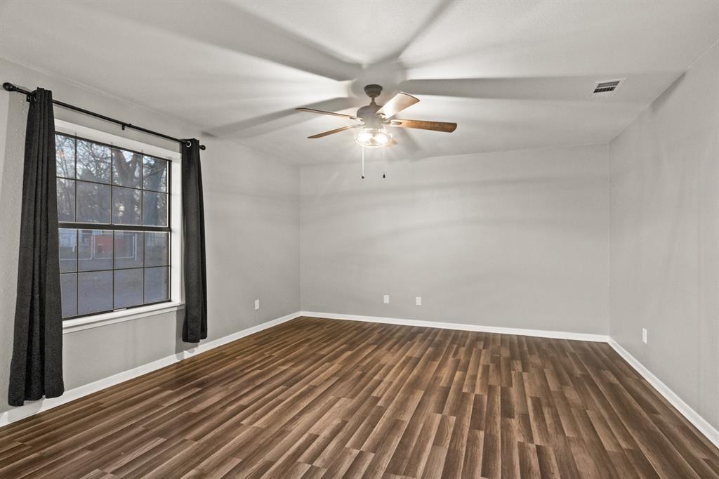 231 Quitman Street Pittsburg, TX 75686 - Photo 15 of 32 wooden floor in an empty room with a window