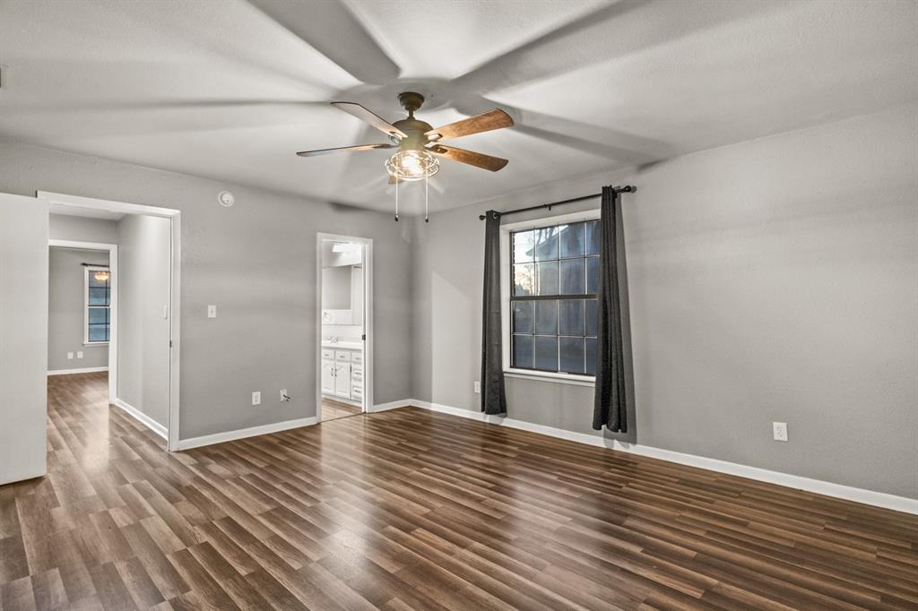 231 Quitman Street Pittsburg, TX 75686 - Photo 16 of 32 a view of an empty room with window and wooden floor