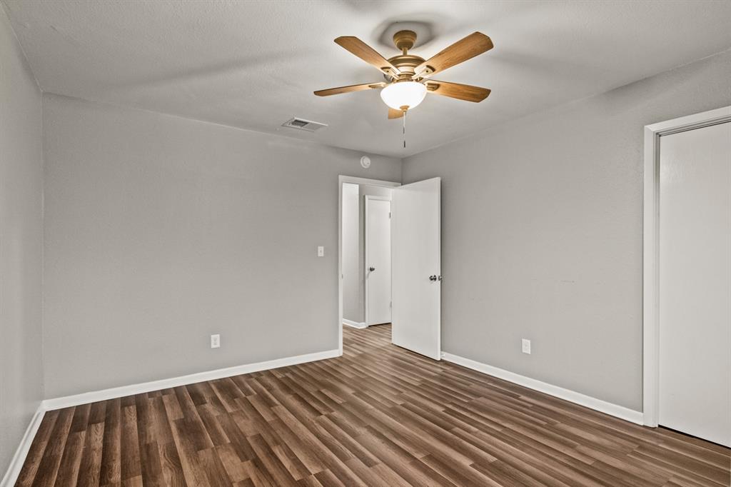231 Quitman Street Pittsburg, TX 75686 - Photo 26 of 32 a view of an empty room with wooden floor