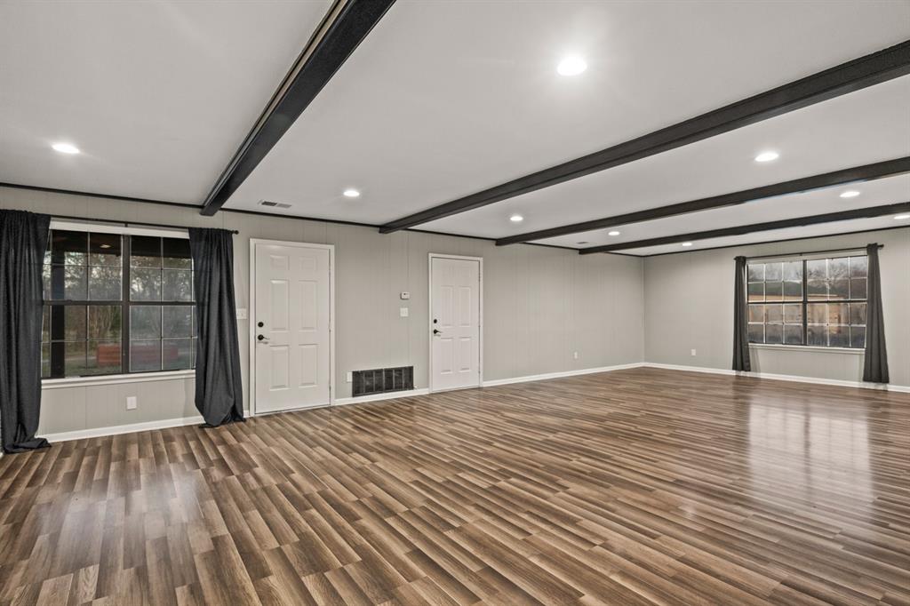 231 Quitman Street Pittsburg, TX 75686 - Photo 5 of 32 a view of an empty room with wooden floor and a window