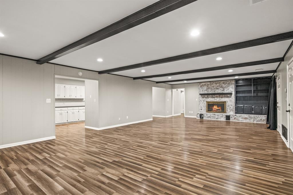 231 Quitman Street Pittsburg, TX 75686 - Photo 9 of 32 a view of empty room with wooden floor and fireplace