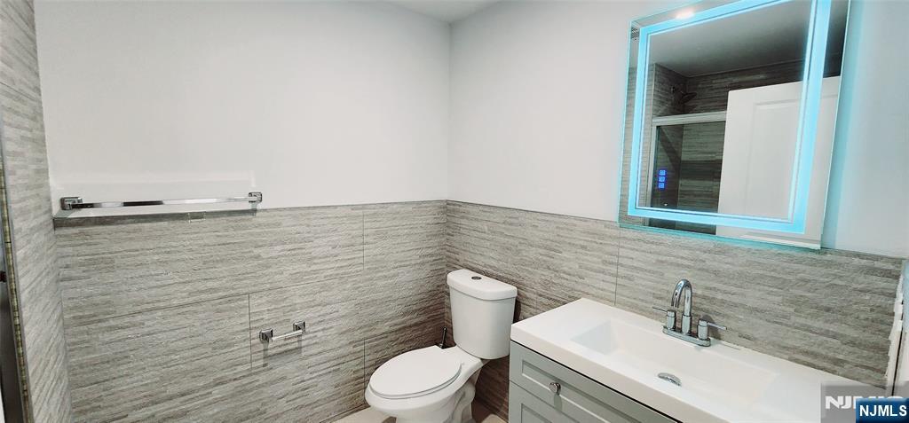 30 Howe Avenue, Unit 301 Passaic, NJ 07055 - Photo 9 of 10 a bathroom with a sink a toilet and mirror
