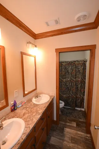 a bathroom with a granite countertop sink a toilet and a mirror