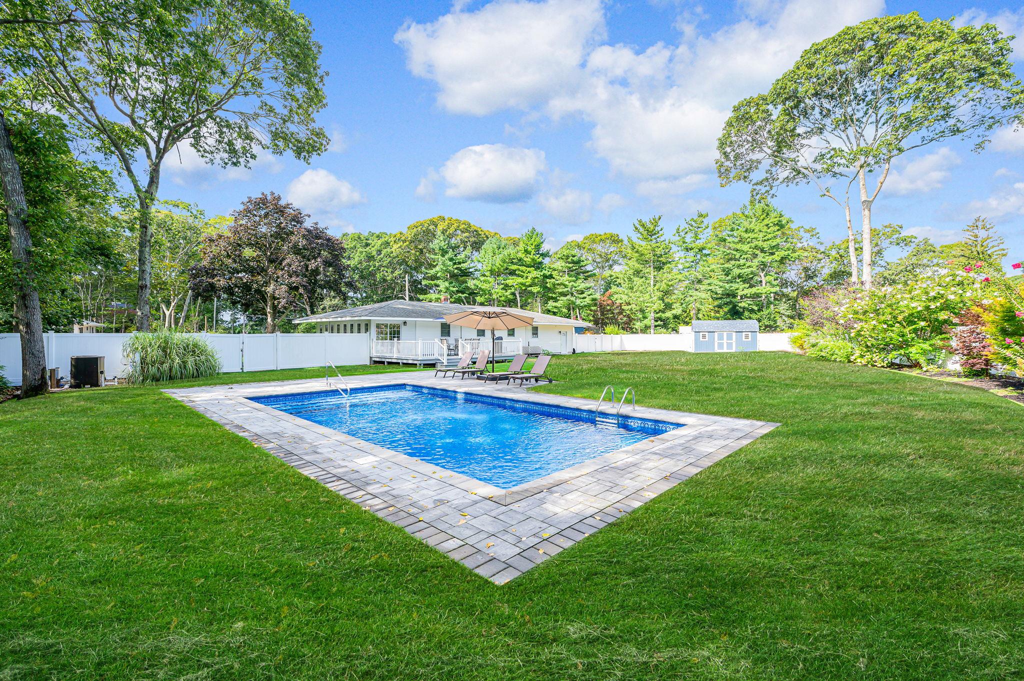 a view of a backyard with swimming pool