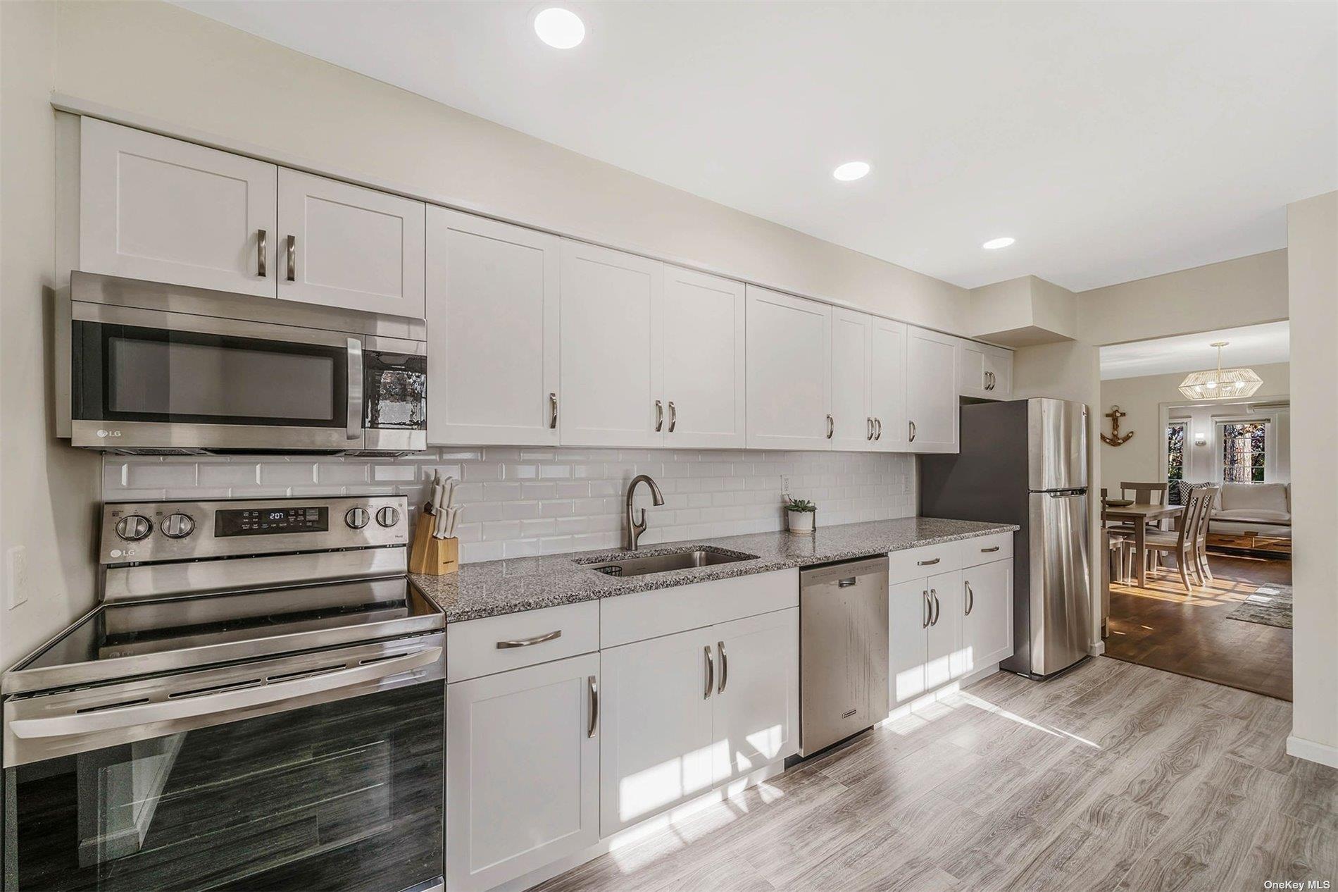 6 Rolling Hill Road Hampton Bays, NY 11946 - Photo 11 of 28 a kitchen with stainless steel appliances a stove microwave and cabinets