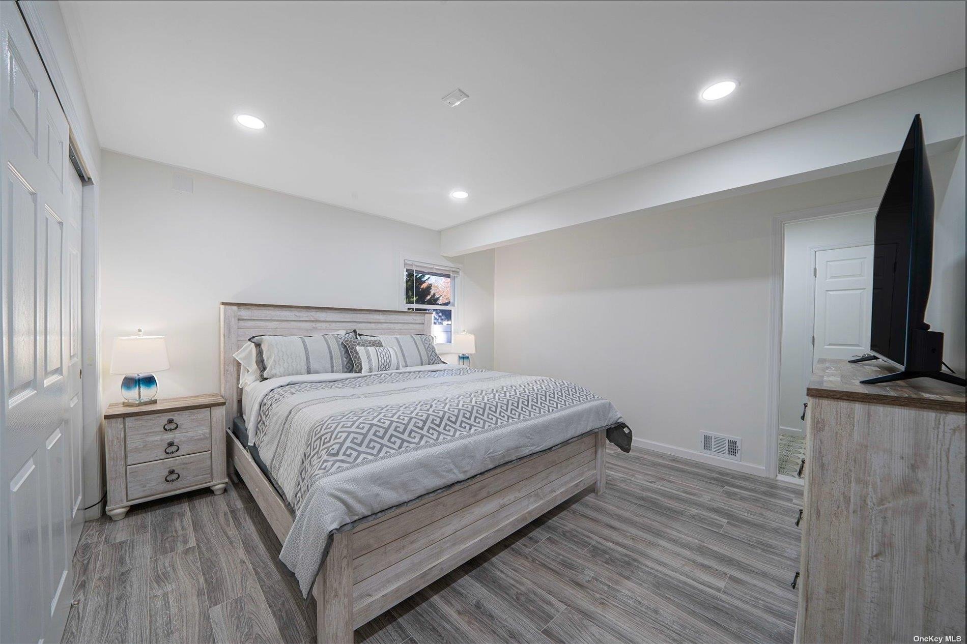 6 Rolling Hill Road Hampton Bays, NY 11946 - Photo 11 of 28 a bedroom with a bed and a flat screen tv