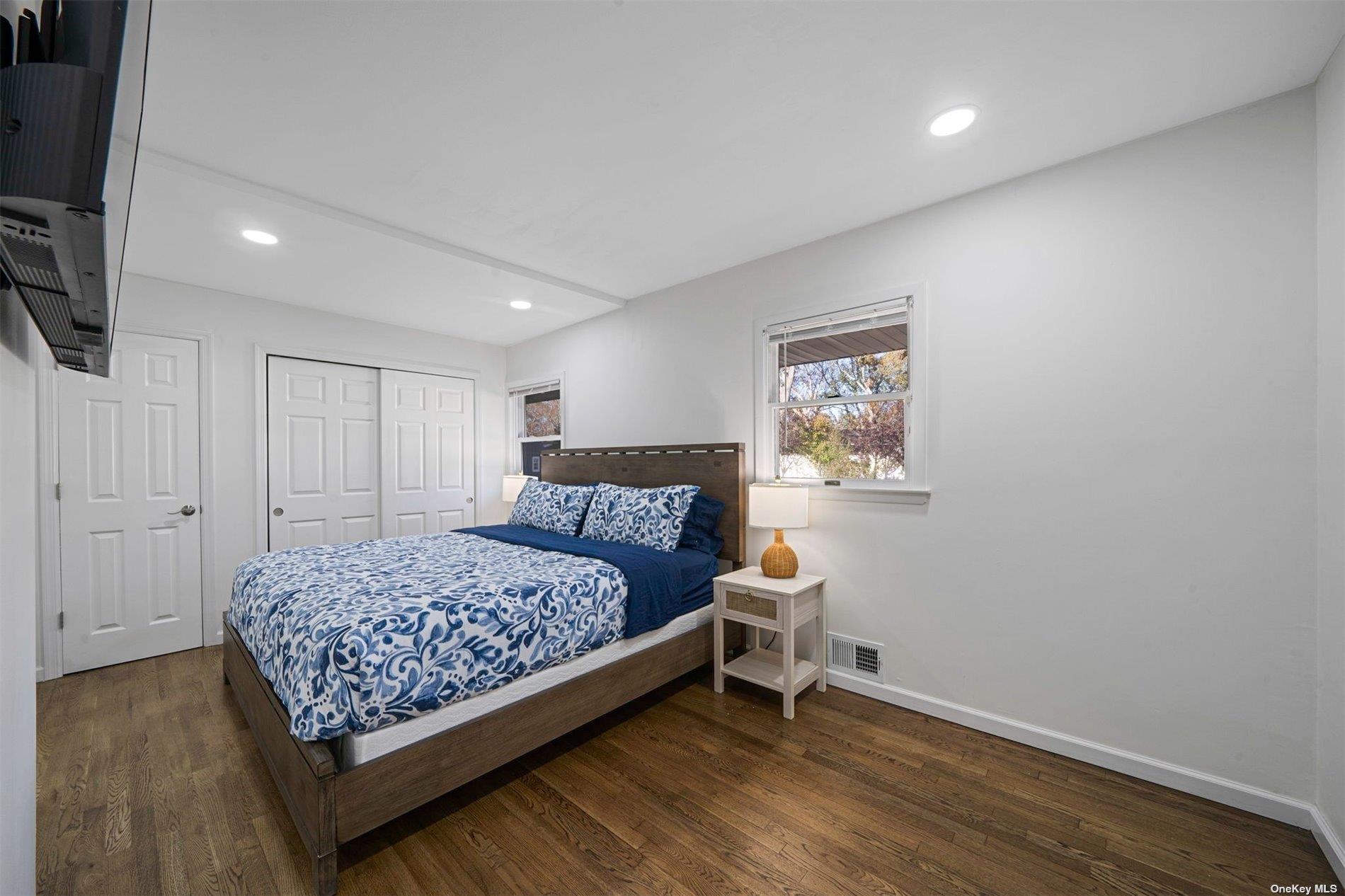 6 Rolling Hill Road Hampton Bays, NY 11946 - Photo 14 of 28 a bedroom with a bed and a flat screen tv