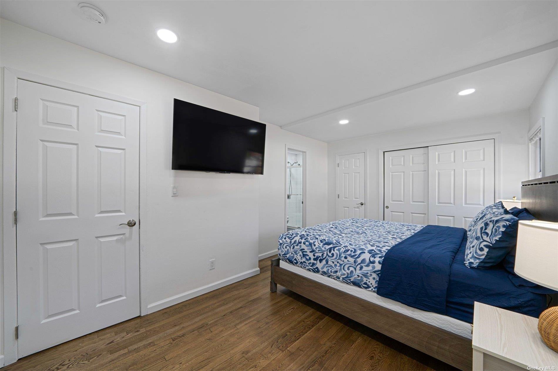 6 Rolling Hill Road Hampton Bays, NY 11946 - Photo 15 of 28 a bedroom with a bed and a flat screen tv