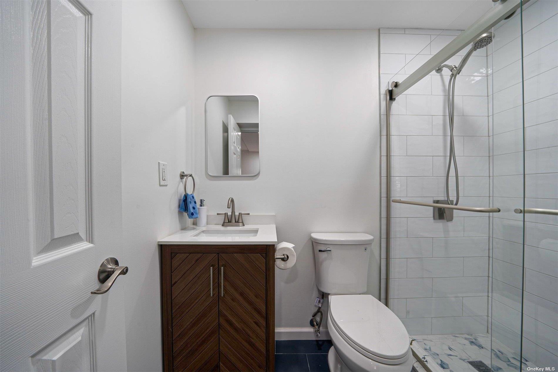 6 Rolling Hill Road Hampton Bays, NY 11946 - Photo 16 of 28 a bathroom with a toilet a sink and shower