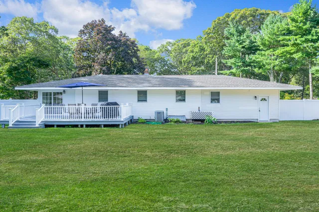 a view of house with backyard and outdoor seating