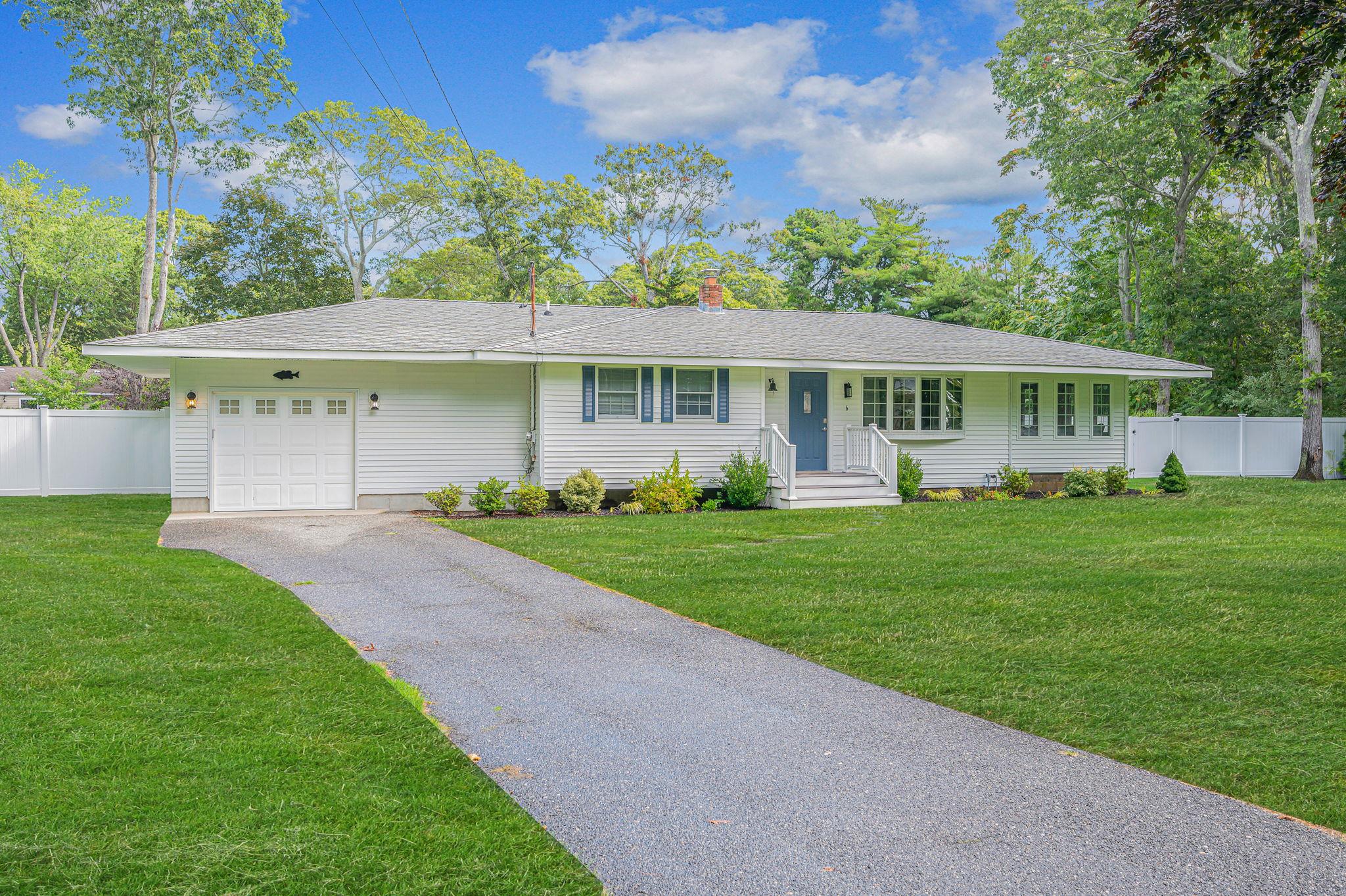 6 Rolling Hill Road Hampton Bays, NY 11946 - Photo 2 of 28 a front view of a house with a garden and plants