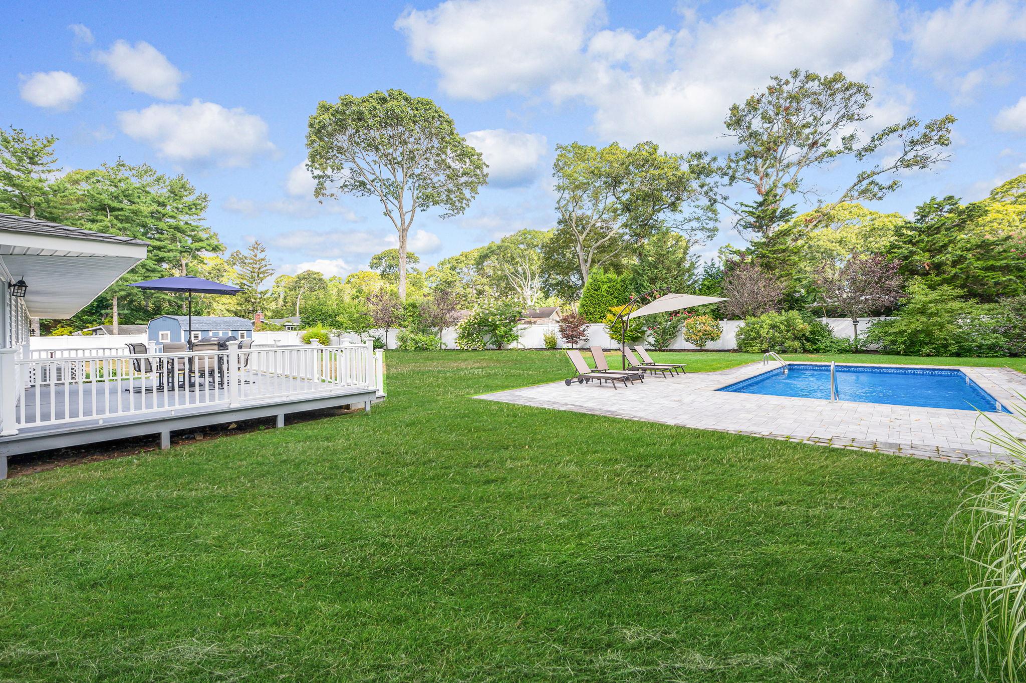 6 Rolling Hill Road Hampton Bays, NY 11946 - Photo 23 of 28 a view of a garden with a house in the background