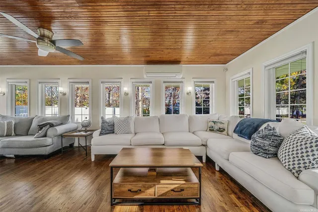 a living room with furniture wooden floor and a large window