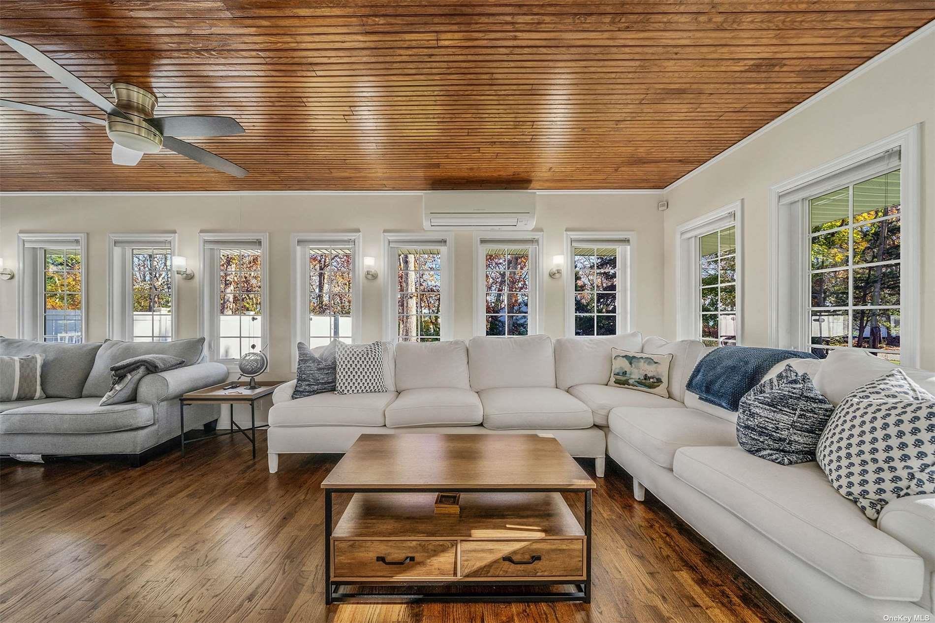 6 Rolling Hill Road Hampton Bays, NY 11946 - Photo 6 of 28 a living room with furniture wooden floor and a large window