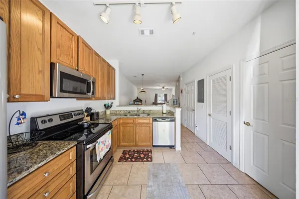 a kitchen with stainless steel appliances granite countertop a stove top oven a sink and a microwave
