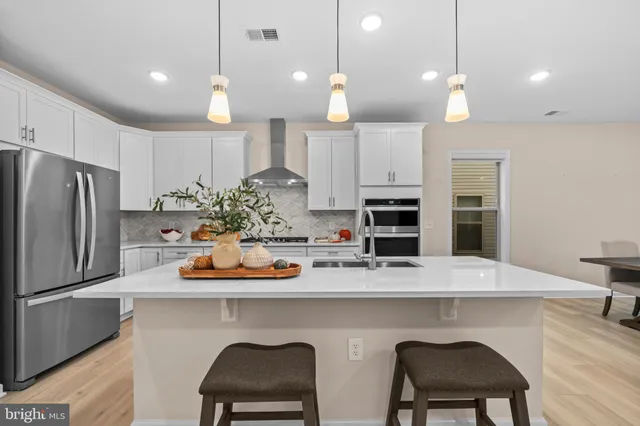 a kitchen with a table chairs refrigerator and microwave